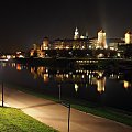 Zdjęcie zrobione z Mostu Grunwaldzkiego, licząc od pierwszego planu, znajdują się Bulwar Poleski, rzeka Wisła i wzgórze Wawel wraz z Zamkiem Królewskim i bazyliką archikatedralna św. Stanisława i św. Wacława.